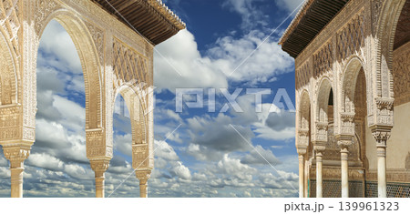 Arches in Islamic (Moorish) style (against the background of a beautiful sky with clouds) in Alhambra, Granada, Spain Arches in Islamic (Moorish) style (against the background of a beautiful sky with clouds) in Alhambra, Granada, Spain 139961323