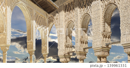 Arches in Islamic (Moorish) style (against the background of a beautiful sky with clouds) in Alhambra, Granada, Spain Arches in Islamic (Moorish) style (against the background of a beautiful sky with clouds) in Alhambra, Granada, Spain 139961331