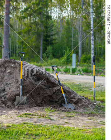 Shovels in sand pile on cleared land during rural farm construction and site preparation work 139961561