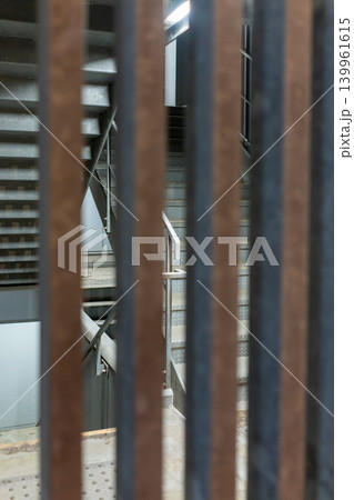 縦格子越しに見る非常階段のインダストリアルな背景素材 縦格子越しに見る非常階段のインダストリアルな背景素材 139961615