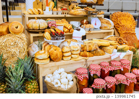 There is large table full of baked items jars of pickles at farm rural market event many foods are neatly arranged. There is large table full of baked items jars of pickles at farm rural market event many foods are neatly arranged. 139961745