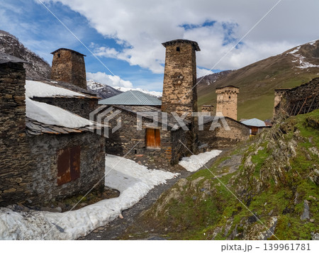 Ushguli, Georgia. Ancient stone homes stand beside a winding path Ushguli, Georgia. Ancient stone homes stand beside a winding path 139961781