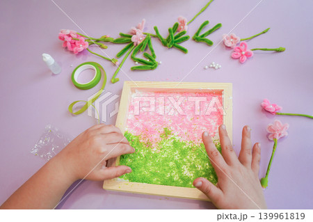 Handmade fuzzy wire flowers on a meadow. Play fosters creativity and finger control. Handmade fuzzy wire flowers on a meadow. Play fosters creativity and finger control. 139961819