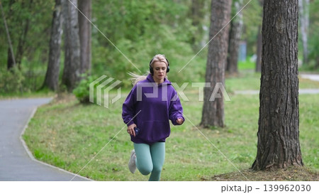 Portrait of young sportswoman jogging during outdoor training in park in the morning. Sport and healthy lifestyle concept 139962030