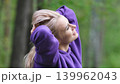 Blonde in purple sweatshirt doing morning exercises, breathing fresh air in forest 139962043