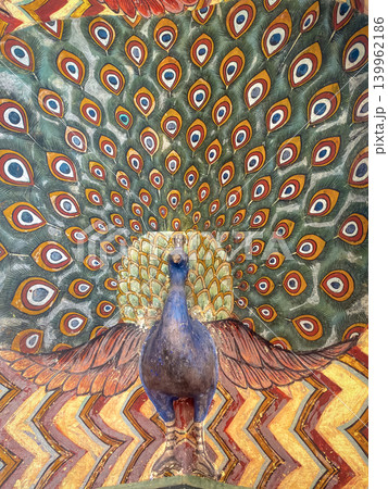 A colorful ceiling painting featuring peacocks, ornaments, and slanted motifs in a palace in Jaipur, India. A colorful ceiling painting featuring peacocks, ornaments, and slanted motifs in a palace in Jaipur, India. 139962186