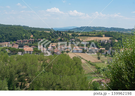 Lush green hills with village houses under bright sky. Perfect for travel brochures, countryside lifestyle branding and peaceful vacation themes Certaldo, Italy. 139962198