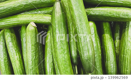 Full frame background of fresh green cucumbers on display at a supermarket grocery counter Full frame background of fresh green cucumbers on display at a supermarket grocery counter 139962569