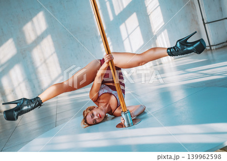 Young woman pole dancer in white interior at sunny day 139962598