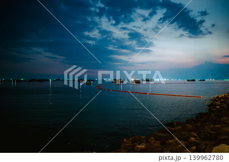 夜の海に並ぶ漁船と赤いオイルフェンスの風景 夜の海に並ぶ漁船と赤いオイルフェンスの風景 139962780