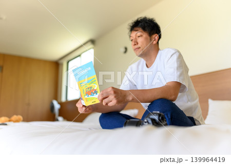 ガイドブックを読む男性 ガイドブックを読む男性 139964419