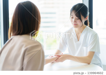 患者の脈拍を測定する医師 139964602