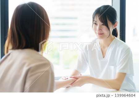 患者の脈拍を測定する医師 139964604
