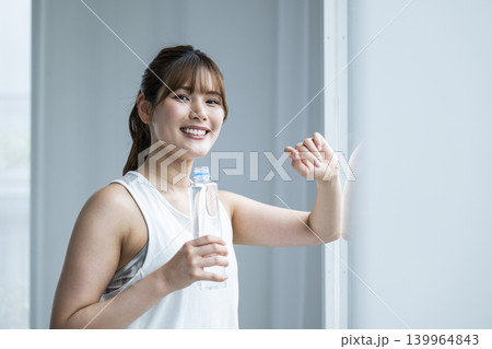 若い女性　スポーツウェア　カメラ目線　水分補給 139964843