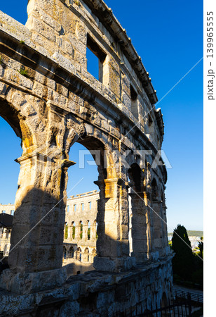 Early morning, sun illuminates stone walls of ancient Roman amphitheater in Pula, Croatia Early morning, sun illuminates stone walls of ancient Roman amphitheater in Pula, Croatia 139965555