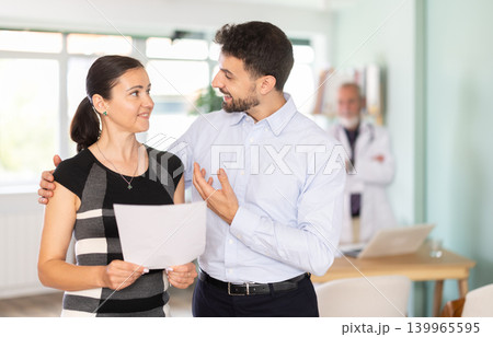 Happy spouses patients of clinic with documents experiences joy from successful outcome of treatment. 139965595