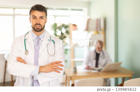 Man in white surgery uniform suit stands in reception area of clinic 139965612