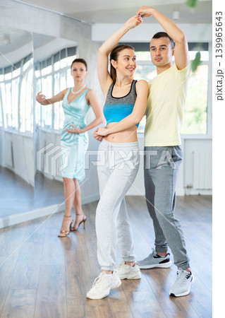 Smiling woman enjoying merengue with man in latin dance class Smiling woman enjoying merengue with man in latin dance class 139965643