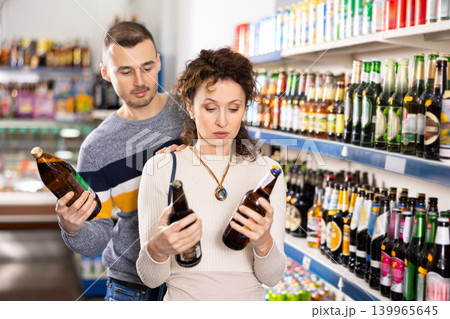 Couple man and woman choosing beer in store 139965645
