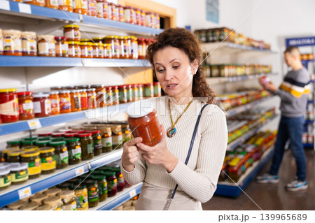 Adult woman chooses lecho in store Adult woman chooses lecho in store 139965689