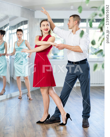 Couple in stage costumes learns waltz dancing during individual lesson Couple in stage costumes learns waltz dancing during individual lesson 139965692