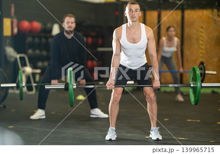 Man performing barbell deadlift during cross training at gym 139965715