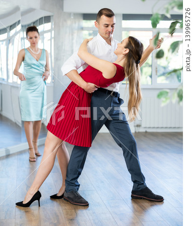 Couple in stage costumes learns waltz dancing during individual lesson 139965726