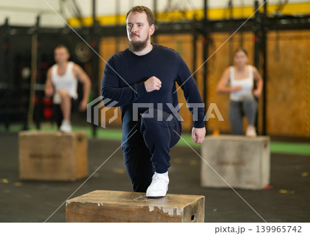 Young bearded man stepping up onto box during cross training 139965742
