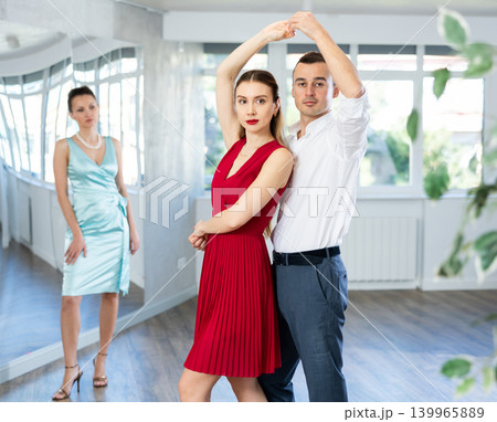 Couple in stage costumes learns waltz dancing during individual lesson 139965889