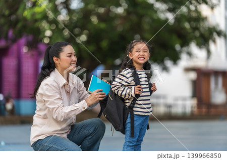 Back to school. Smiling mother and preschool student girl with backpack and book. 139966850
