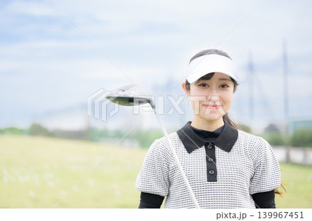 ゴルフ練習場で笑顔のカメラ目線の女性のスポーツライフスタイルイメージ 139967451