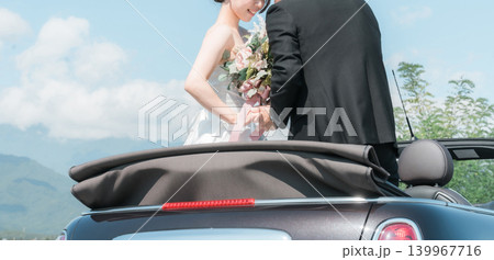 愛車とフォトウェディングを撮る新郎新婦（オープンカー） 139967716
