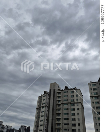It is a view of dark clouds and an apartment complex. It is a view of dark clouds and an apartment complex. 139967777