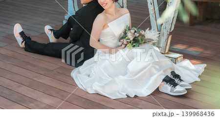 LOVEのオブジェの前でウェディングフォトを撮る新郎新婦 139968436