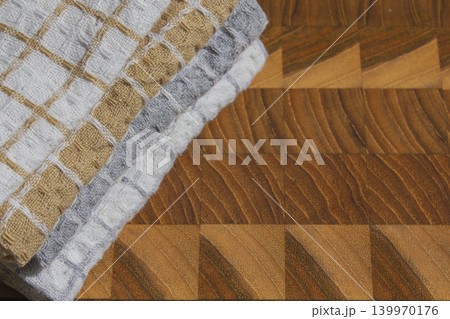 It is a cutting board and a dishcloth. It is a cutting board and a dishcloth. 139970176