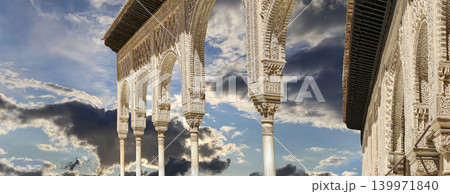 Arches in Islamic (Moorish) style (against the background of a beautiful sky with clouds) in Alhambra, Granada, Spain Arches in Islamic (Moorish) style (against the background of a beautiful sky with clouds) in Alhambra, Granada, Spain 139971840