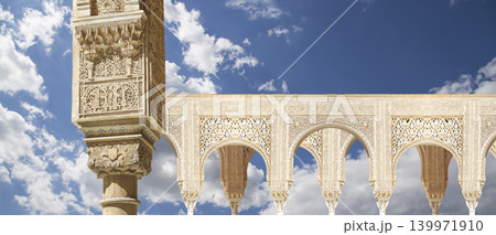 Arches in Islamic (Moorish) style (against the background of a beautiful sky with clouds) in Alhambra, Granada, Spain Arches in Islamic (Moorish) style (against the background of a beautiful sky with clouds) in Alhambra, Granada, Spain 139971910