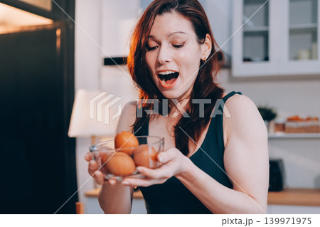 Woman preparing green smoothie in bright kitchen with fresh fruits and vegetables, healthy eating lifestyle moment in natural daylight Woman preparing green smoothie in bright kitchen with fresh fruits and vegetables, healthy eating lifestyle moment in natural daylight 139971975