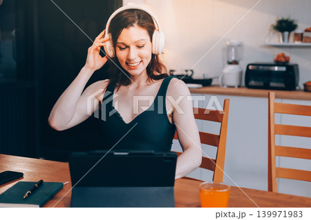 Woman preparing green smoothie in bright kitchen with fresh fruits and vegetables, healthy eating lifestyle moment in natural daylight 139971983