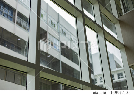 Glass Atrium Inside Building With Sky View, A bright photo of glass atrium building, towering transparent roof revealing clear clouds above interior, for modern architecture or urban documentary. 139972182