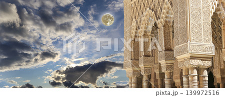 Columns in Islamic (Moorish) style in Alhambra (against the background of a beautiful evening sky with clouds, with the super moon), Granada, Spain Columns in Islamic (Moorish) style in Alhambra (against the background of a beautiful evening sky with clouds, with the super moon), Granada, Spain 139972516