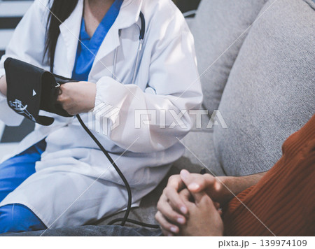 Doctor checks patient's blood pressure with cuff and stethoscope in a medical Doctor checks patient's blood pressure with cuff and stethoscope in a medical 139974109