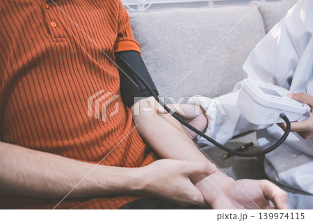 Doctor checks patient's blood pressure with cuff and stethoscope in a medical Doctor checks patient's blood pressure with cuff and stethoscope in a medical 139974115
