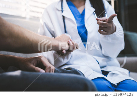 A doctor is holding hands with an elderly patient. A doctor is holding hands with an elderly patient. 139974128