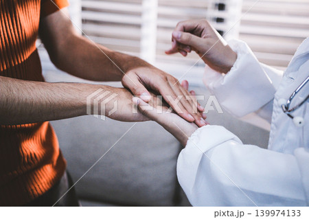 A doctor is holding hands with an elderly patient. A doctor is holding hands with an elderly patient. 139974133