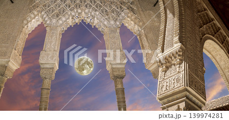 Arches in Islamic (Moorish) style (against the sunset with the super moon) in Alhambra, Granada, Spain Arches in Islamic (Moorish) style (against the sunset with the super moon) in Alhambra, Granada, Spain 139974281