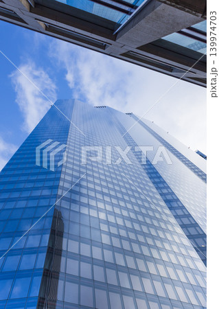 Low angle view of a modern glass skyscraper in the city 139974703