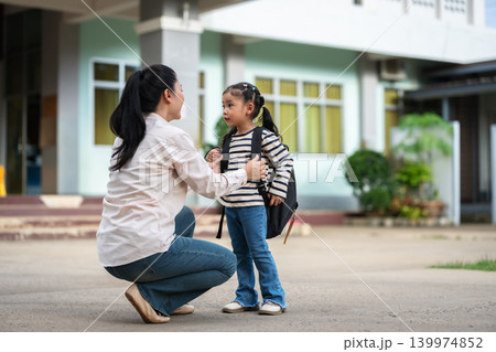 mother adjusting her daughter's backpack before the first day of school. Back to school concept. 139974852