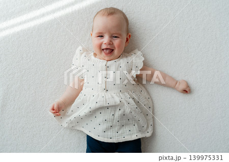 Adorable newborn baby girl looking joyful and calm on a white textile background. High-quality stock portrait capturing genuine happy emotions of early childhood Adorable newborn baby girl looking joyful and calm on a white textile background. High-quality stock portrait capturing genuine happy emotions of early childhood 139975331