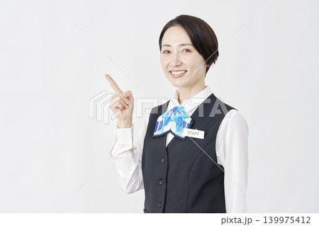 左側を指差す女性スタッフ 受付嬢・銀行員 白背景 左側を指差す女性スタッフ 受付嬢・銀行員 白背景 139975412
